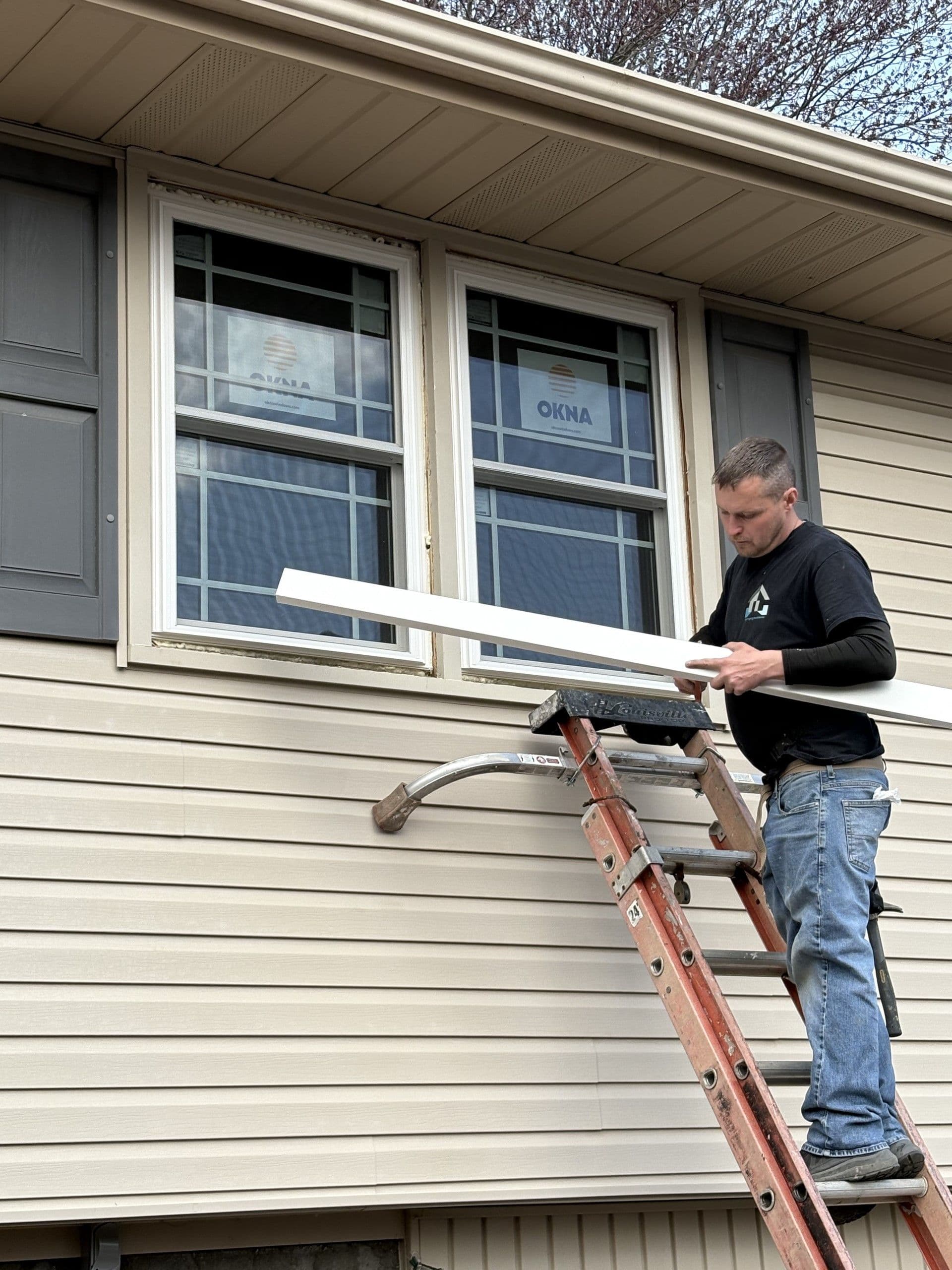 Window Replacement - person on ladder working on windows